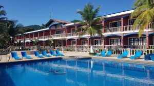 Piscina y sillas de sol, vista a las habitaciones hotel en Capurganá